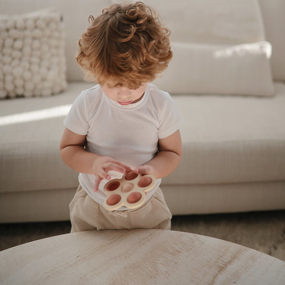 Mushie® Otroška igrača POP-IT Flower Rose/Blush/Shifting Sand Mushie